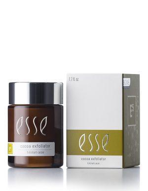 A jar of Esse Cocoa Exfoliator is displayed beside its corresponding box. The jar, dark brown with a white label and silver lid, contains 1.7 fl. oz. of exfoliator, while the box features a design in white and olive green with matching branding.