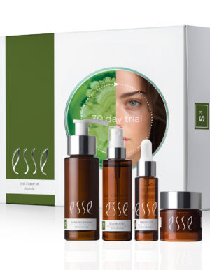 The Esse Sensitive Skin Trial/Travel Set includes a cream cleanser in a pump bottle, a toner in a spray bottle, a repair oil with a dropper, and a nourishing moisturizer in a jar, all displayed in front of a white and green box featuring an illustrated woman's face.