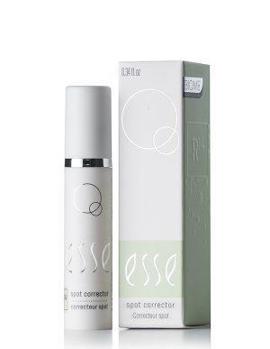A white and light green box labeled "Esse Spot Corrector" stands next to the matching cylindrical product container, which has a light gray cap. Both the box and the container prominently display the brand's logo, along with text in green and gray fonts.