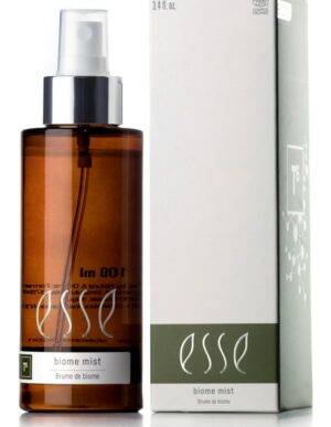 A brown cylindrical spray bottle labeled "Esse Biome Mist" is positioned beside its box packaging. The predominantly white box features green accents at the bottom and displays the same product name. The bottle is equipped with a white spray nozzle and a silver collar.